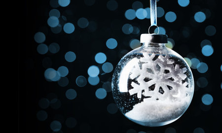 Christmas ball with snow and snowflake inside against blurred lights on dark background. Banner designの写真素材