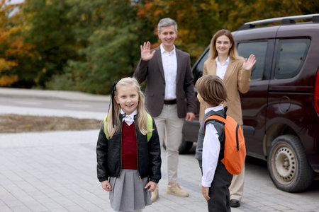 Parents taking their children to school near car outdoors, selective focusの写真素材