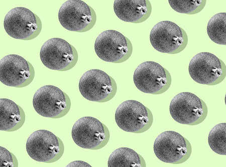 Festive pattern of shiny silver Christmas balls. Repetitive ornament on light green backgroundの写真素材
