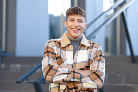 Portrait of smiling man with crossed arms near railings outdoorsの写真素材