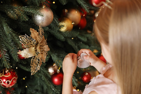 Little girl decorating Christmas tree at home, closeupの写真素材