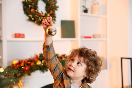 Little boy with Christmas bauble at homeの写真素材