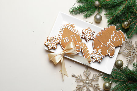 Tasty gingerbread cookies and festive decor on beige table, flat lay. Space for textの写真素材