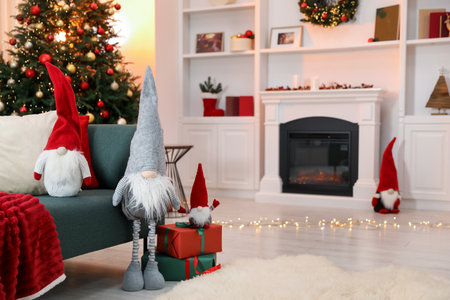 Funny Christmas gnomes on sofa in decorated room, space for textの写真素材