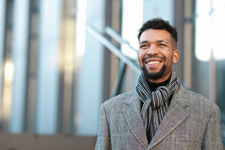 Smiling man in suit on city street.の写真素材