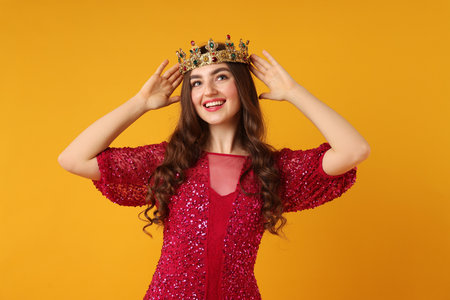 Woman wearing luxury crown on orange backgroundの写真素材