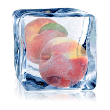 Fresh peaches in ice cube isolated on whiteの写真素材