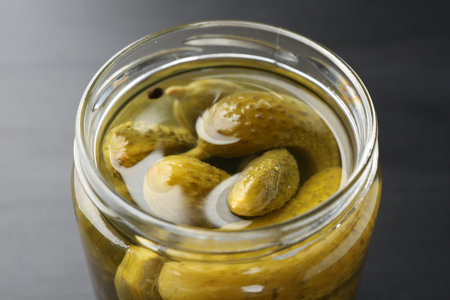 Pickled cucumbers in jar on black table, closeupの写真素材