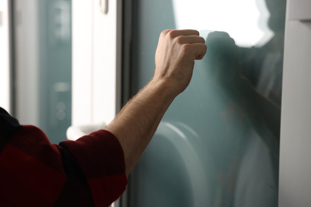 Man knocking on apartment door, closeup viewの写真素材