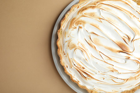 Delicious meringue pie on light brown table, top view. Space for textの写真素材