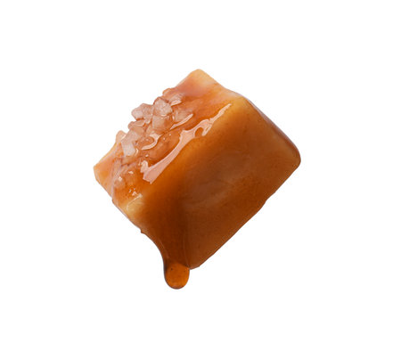 Tasty candy with salt and caramel sauce isolated on whiteの写真素材