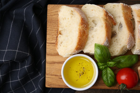 Tasty baguette served with butter, tomato and basil on table, flat lay. Space for textの写真素材