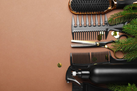 Hairdresser's tools and Christmas decor on brown background, flat lay. Space for textの写真素材