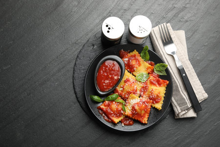 Delicious ravioli with tomato sauce, cheese and basil served on gray table, flat lay. Space for textの写真素材
