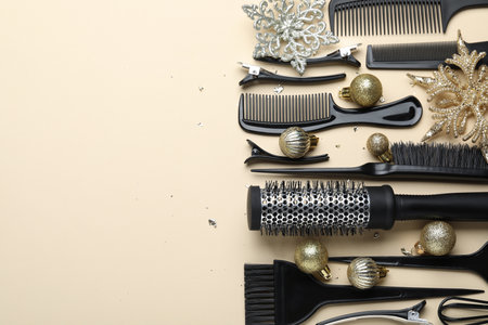 Hairdresser's tools and Christmas decor on beige background, flat lay. Space for text