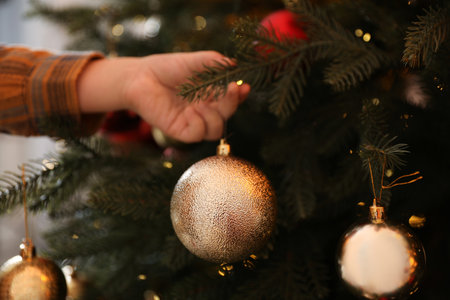 Little boy decorating Christmas tree at home, closeupの写真素材