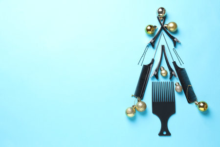 Christmas tree made of hairdresser's tools and baubles on light blue background, flat lay. Space for textの写真素材