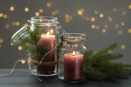 Beautiful Christmas lanterns and festive decor on gray wooden table against blurred lights, closeup. Bokeh effectの写真素材