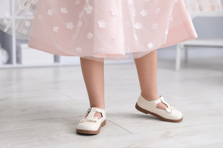 Little girl wearing beautiful dress and shoes indoors, closeupの写真素材