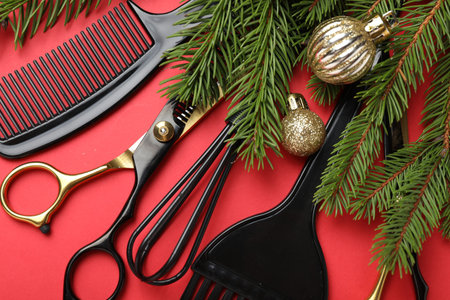 Different hairdresser's tools and Christmas decor on red background, flat layの写真素材
