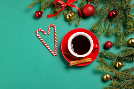 Aromatic coffee in cup and Christmas decor on green background, flat lay. Space for textの写真素材