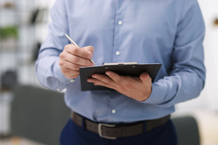 Real estate appraisal. Inspector with clipboard conducting property valuation at home, closeup