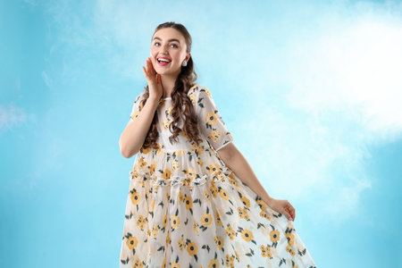 Beautifully dressed young woman on light blue backgroundの写真素材