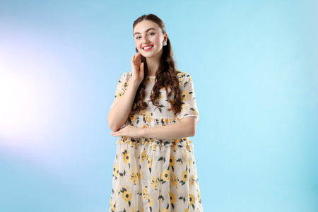 Beautifully dressed young woman on light blue backgroundの写真素材