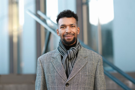 Portrait of handsome man in scarf and suit on city street