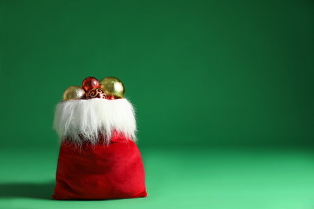 Santa Claus bag with baubles on green background, space for text. Merry Christmasの写真素材