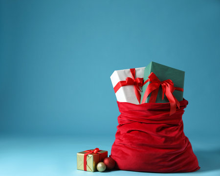 Santa Claus bag with Christmas gifts and baubles on light blue background. Space for textの写真素材