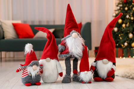 Funny Christmas gnomes on floor in decorated roomの写真素材