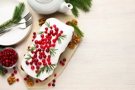 Tasty Christmas cake with cranberries and rosemary served on light wooden table, flat lay. Space for textの写真素材