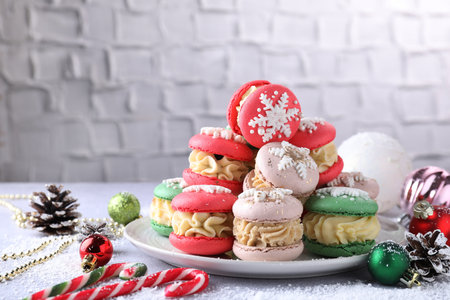 Tasty Christmas macarons and festive decor on light table. Space for textの写真素材