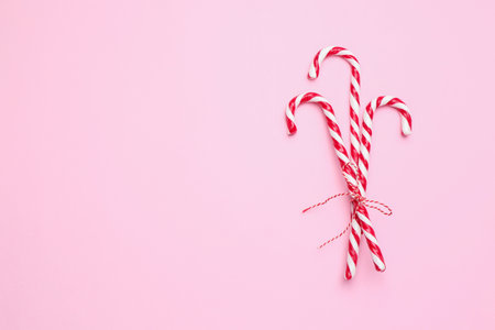 Merry Christmas and Happy New Year. Tasty candy canes on pink background, top view. Space for textの写真素材