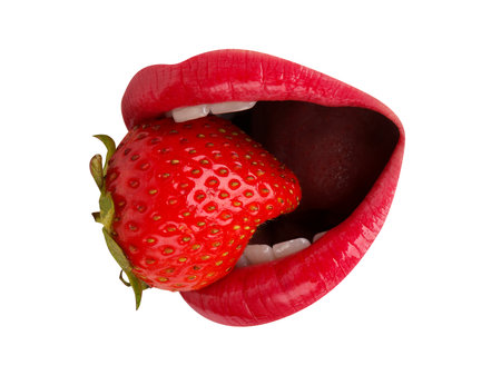 Woman with red lips holding fresh strawberry in her mouth on white background, closeupの写真素材