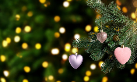 Christmas tree branch with ornaments against blurred lights on dark background, bokeh effect. Banner designの写真素材