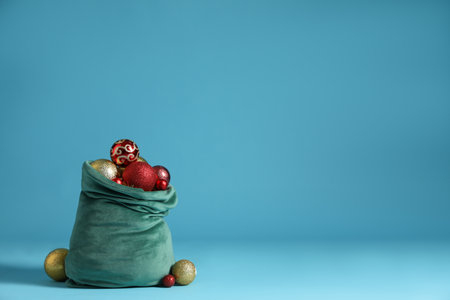 Santa Claus bag with baubles on light blue background, space for text. Merry Christmasの写真素材
