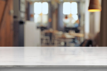 Empty white marble table in cafeteria, blurred background. Space for design