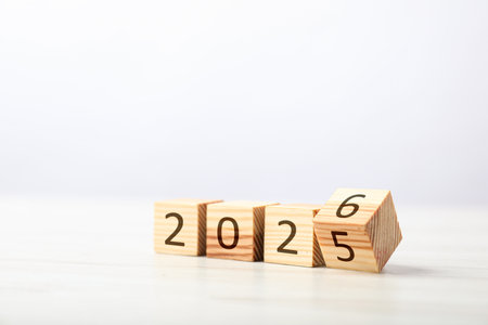 New year. Flipping cube with number 5 and 6 to make 2026 on white table against light background,...