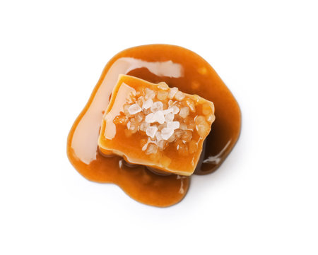 Tasty candy with salt and caramel sauce isolated on white, top viewの写真素材