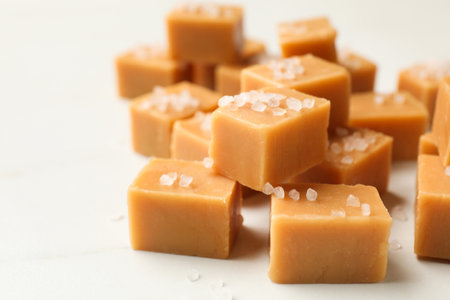 Tasty caramel candies with salt on light table, closeup. Space for textの写真素材