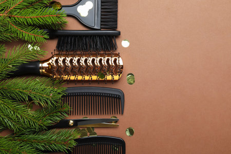 Hairdresser's tools and Christmas decor on brown background, flat lay. Space for textの写真素材