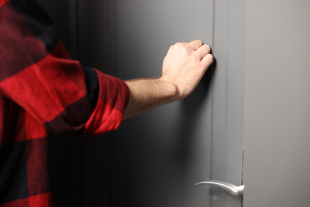 Man knocking on apartment door, closeup viewの写真素材