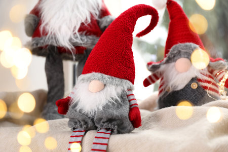 Christmas gnomes on blanket near window at home, closeup. Bokeh effectの写真素材