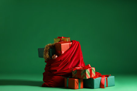 Christmas gifts, tinsel and baubles on green background. Space for textの写真素材