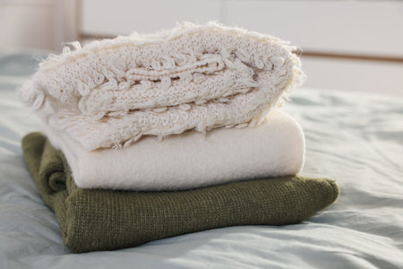 Stack of clean clothes on bed indoors, closeupの写真素材