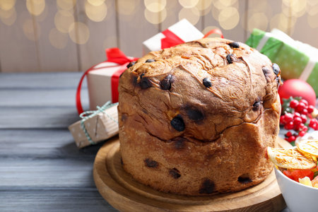 Tasty Christmas panettone cake and gift boxes on gray wooden tableの写真素材