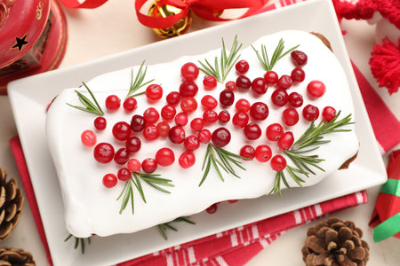 Tasty Christmas cake with cranberries and festive decor on beige table, flat layの写真素材