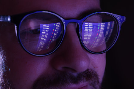 Man wearing glasses with reflection on black background, closeupの写真素材